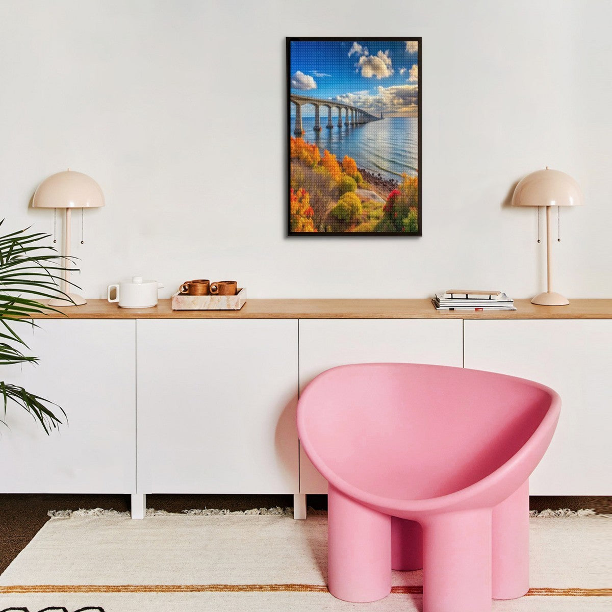 Modern interior with a pink chair, wooden desk, and landscape painting on the wall.