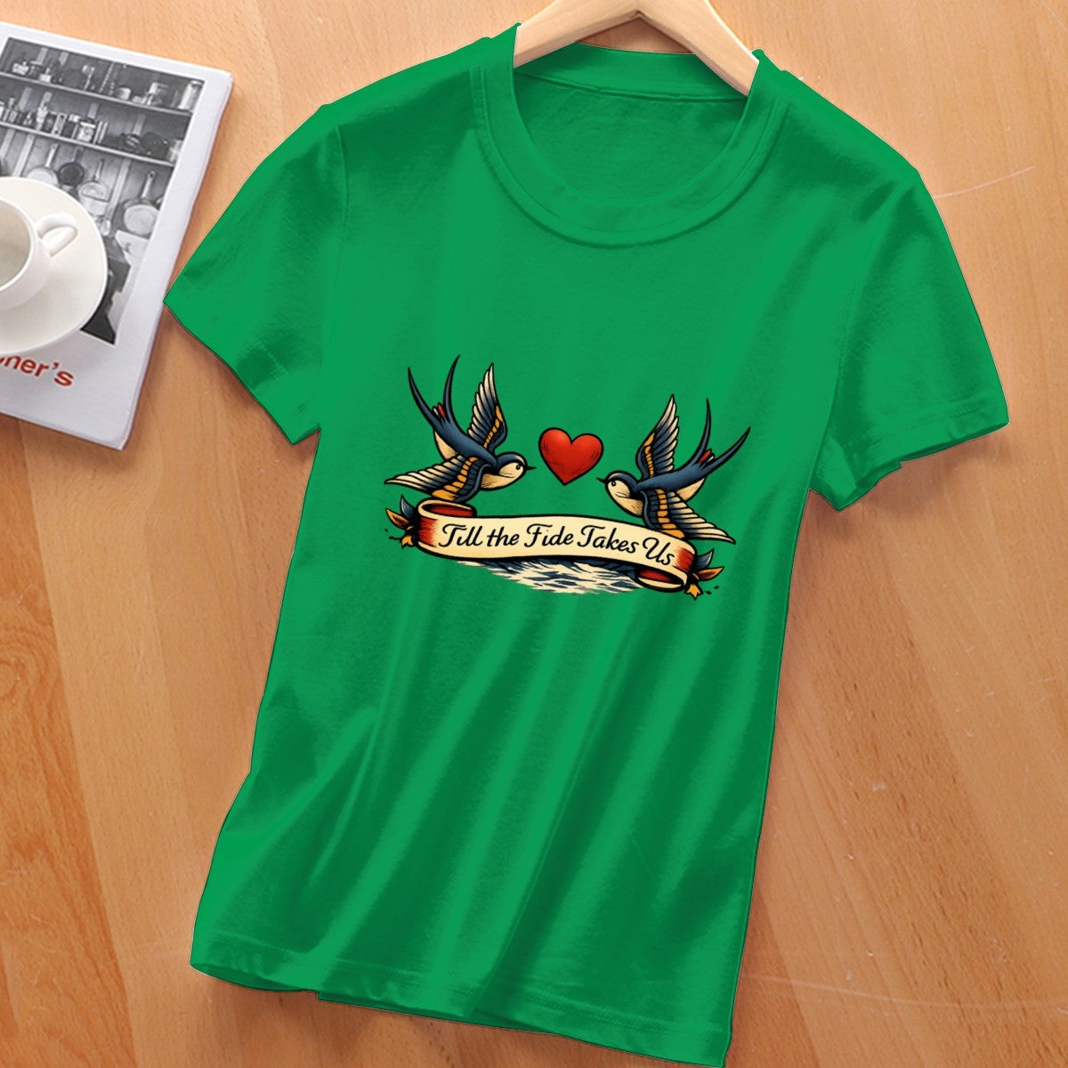 Green t-shirt with tattoo-style design on a wooden surface