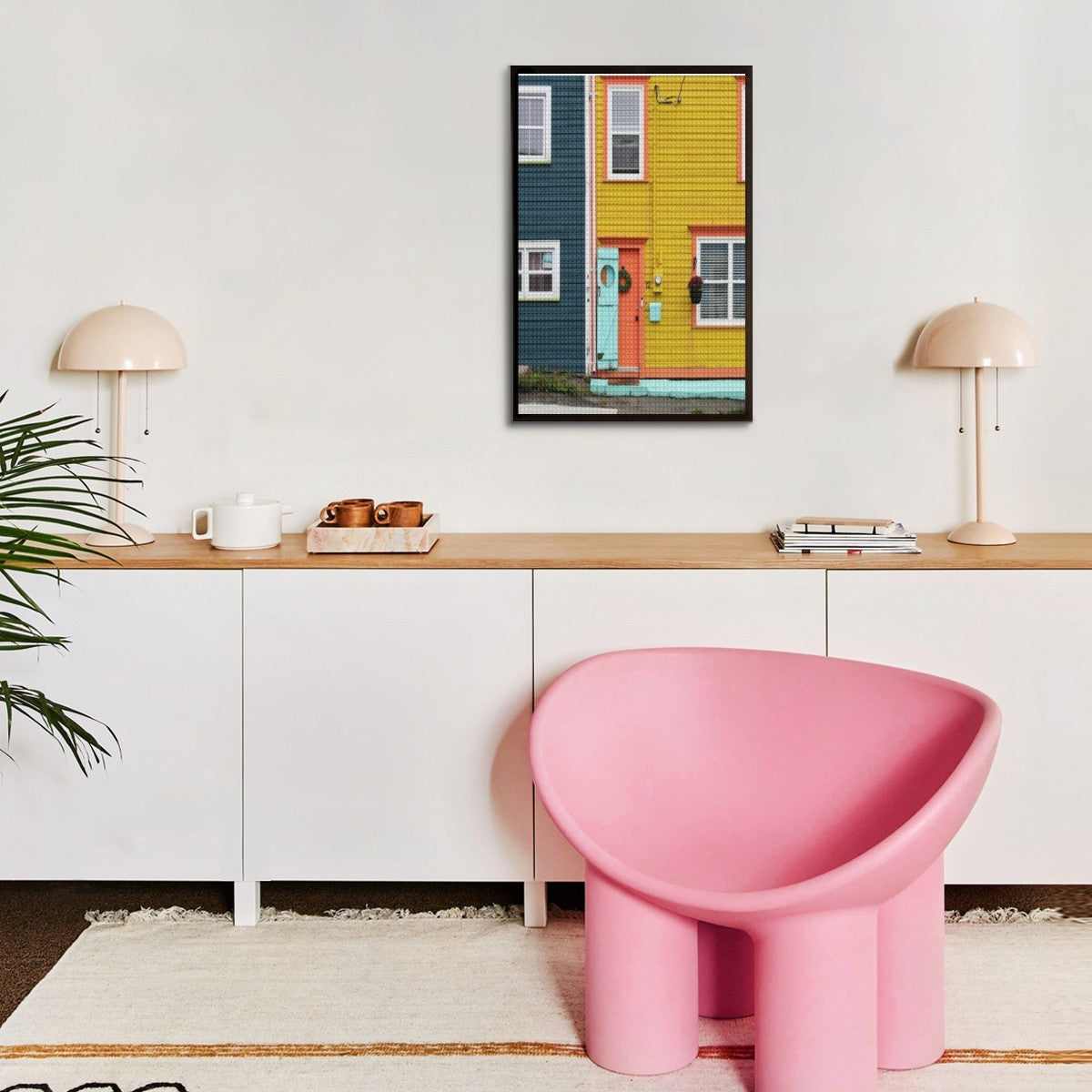 Modern interior with a pink chair, wooden desk, and colorful wall art.